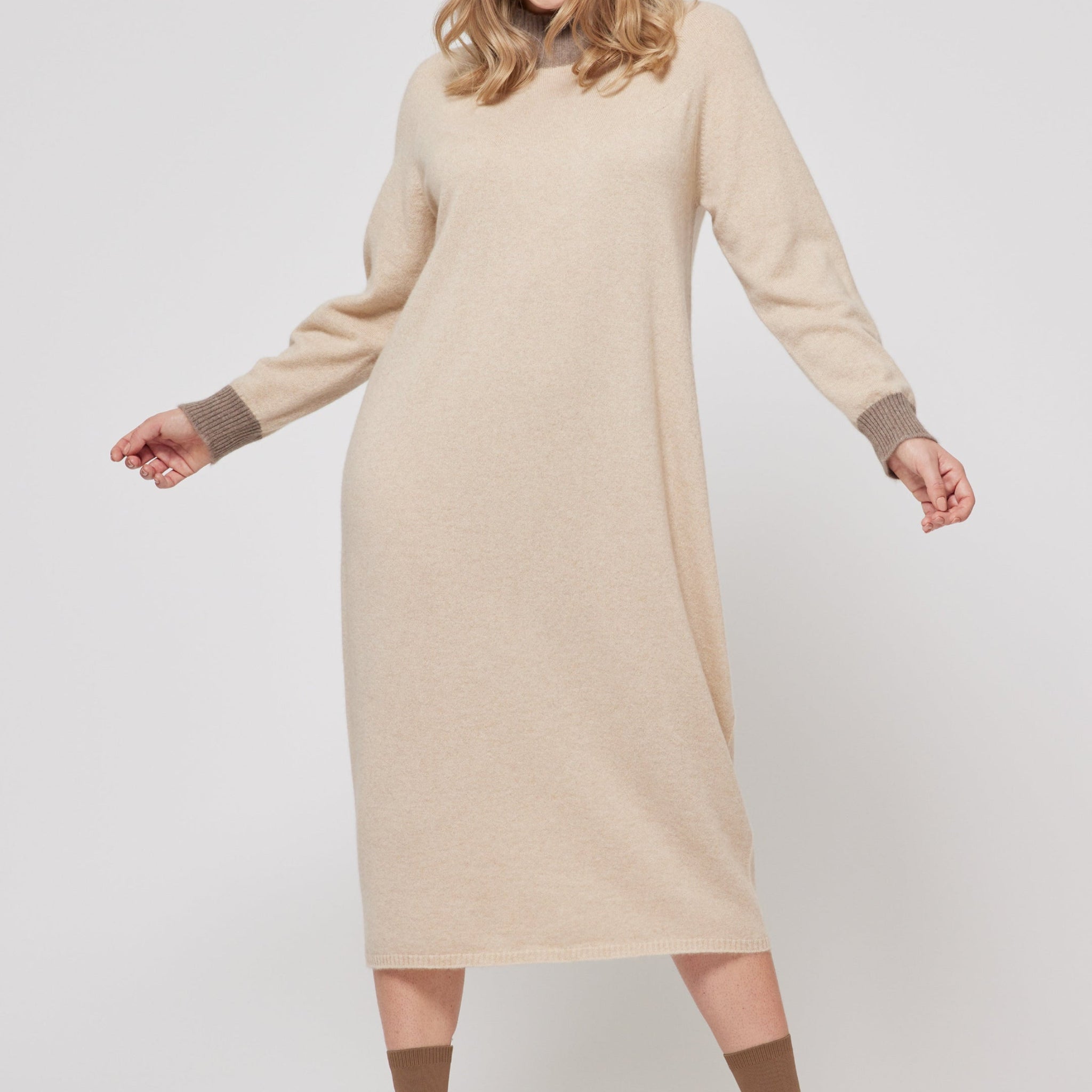Woman wearing a beige dress with brown socks on a white background